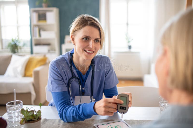 Nurse, caregiver or healthcare worker with senior woman patient, measuring blood glucose indoors. Nurse, caregiver or healthcare worker with senior woman patient, measuring blood glucose indoors.