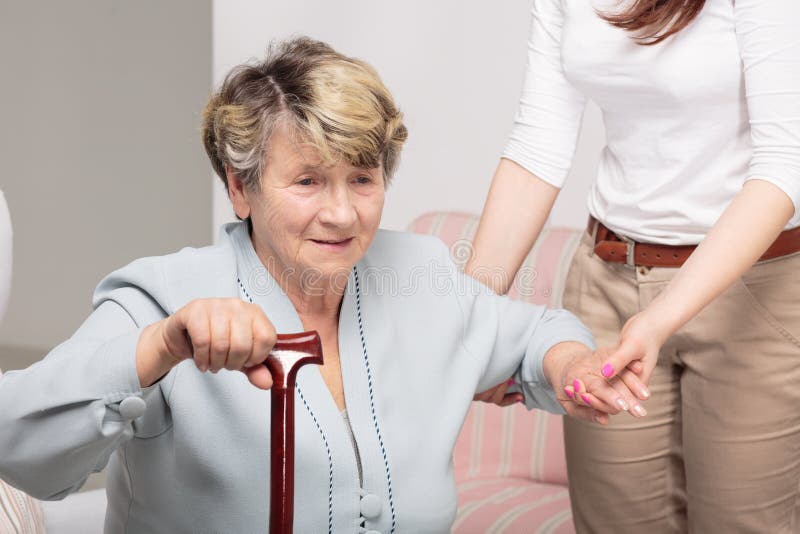 Caregiver supporting senior woman with walking stick stock photos Caregiver supporting senior woman with walking stick stock photos