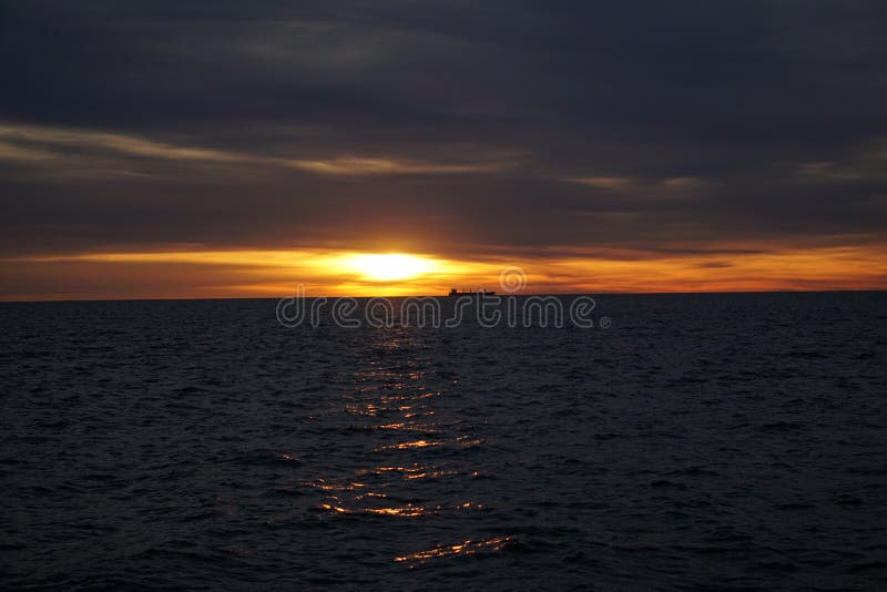 Cargo boat on the horizon at sunrise stock image Cargo boat on the horizon at sunrise stock image