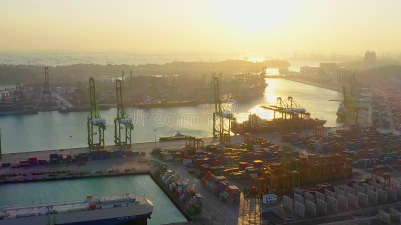 Cargo container transport ship and crane at Singapore sea port industrial district, silhouette sunset. Logistic industry concept