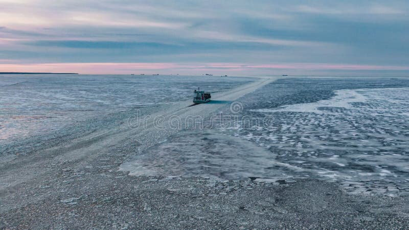 Cargo ship with containers sails through ice hummocks stock images