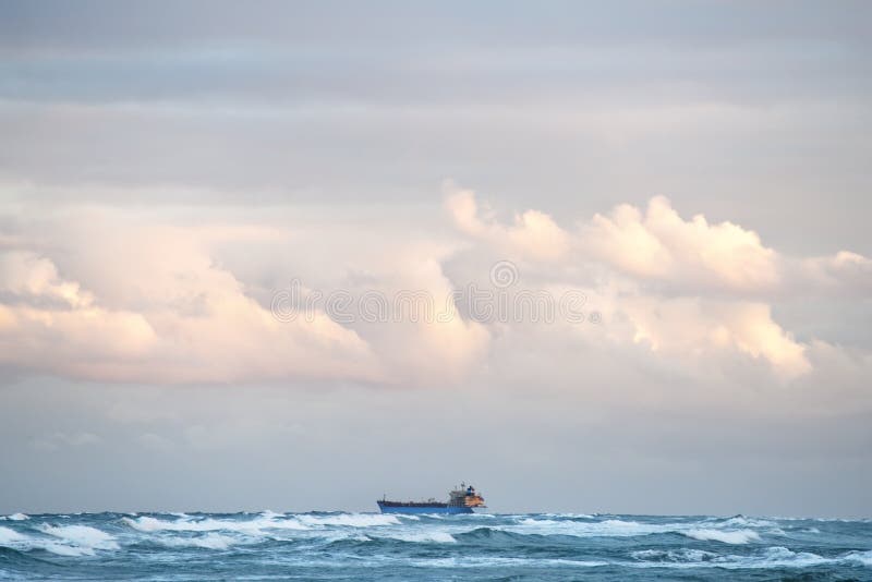 A cargo ship standing far in the ocean royalty free stock photography