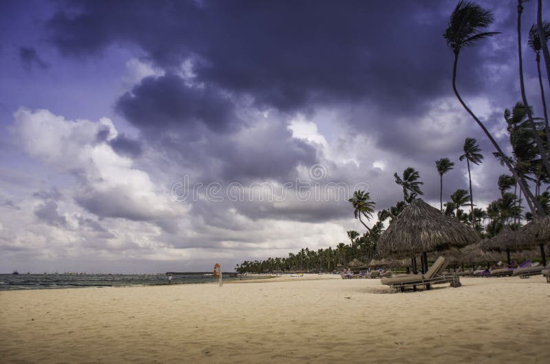 Caribbean beach with golden sand with storm clouds