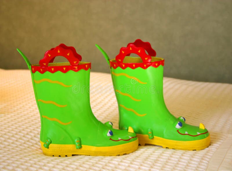 Little girl's comical boots, bright green with red handles, blue eyes, and yellow nose. Little girl's comical boots, bright green with red handles, blue eyes, and yellow nose