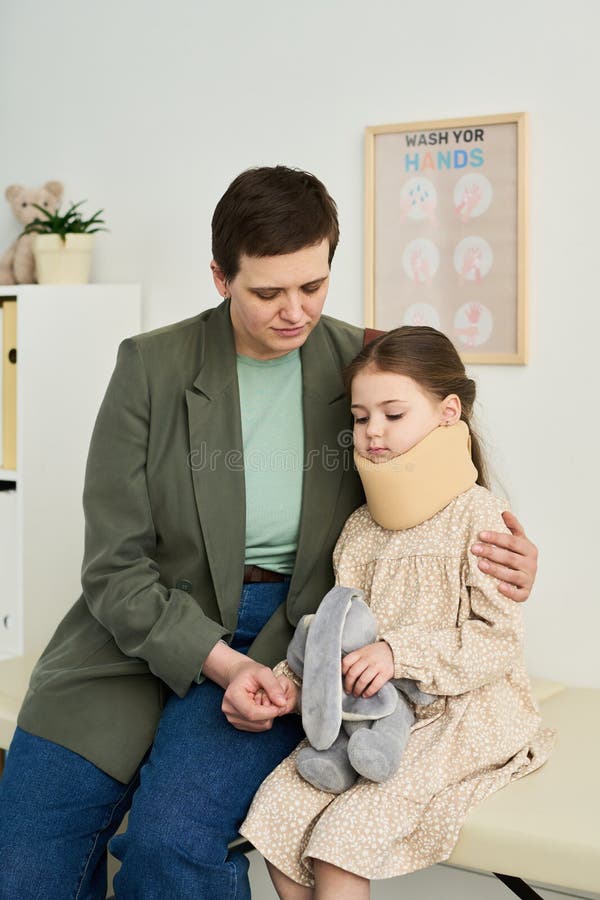 Comforting Young Girl Holding Stuffed Elephant at Doctor Office stock image