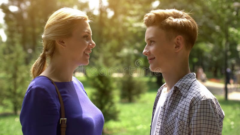 Caring mother looking at her teenage son with tenderness and love, adolescence