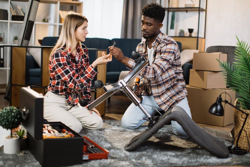 Caring wife helping husband assembling chair at home royalty free stock images