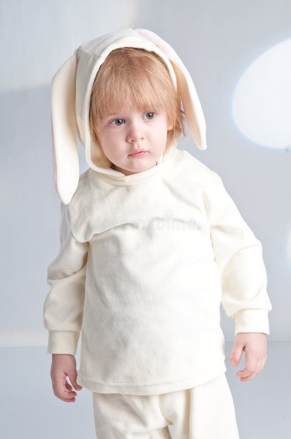 Carino bimbo in costume da coniglio in piedi sui piedi, che sembra seriamente isolato fotografia stock Carino bimbo in costume da coniglio in piedi sui piedi, che sembra seriamente isolato fotografia stock