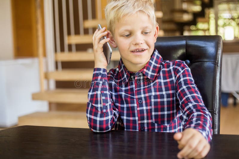 Carino ragazzo caucasico in camicia che parla al telefono. Concetto moderno. Tecnologia immagini stock libere da diritti Carino ragazzo caucasico in camicia che parla al telefono. Concetto moderno. Tecnologia immagini stock libere da diritti