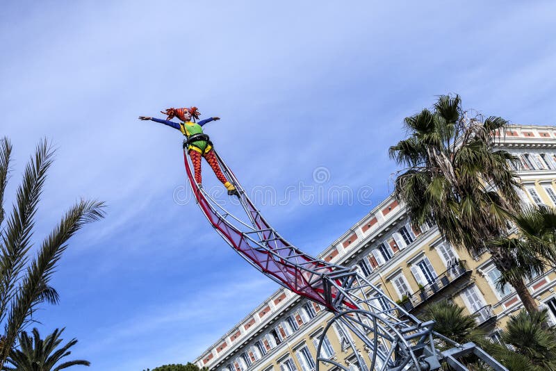 Carnaval famoso de Niza, batalla del ` de las flores Una mujer del acróbata con el traje del payaso en fondo del cielo foto de archivo libre de regalías Carnaval famoso de Niza, batalla del ` de las flores Una mujer del acróbata con el traje del payaso en fondo del cielo foto de archivo libre de regalías