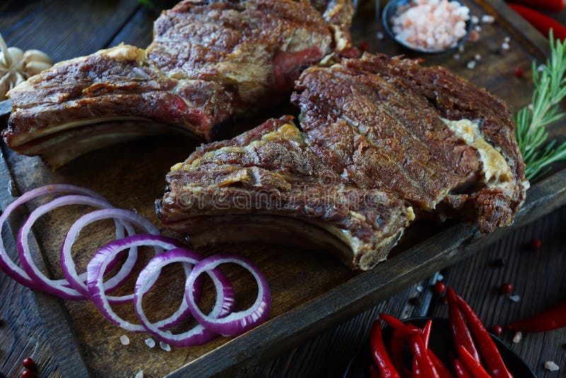 Carne arrostita con le cipolle, l'aglio, le spezie, le erbe fresche, il peperone ed il sale fotografie stock Carne arrostita con le cipolle, l'aglio, le spezie, le erbe fresche, il peperone ed il sale fotografie stock