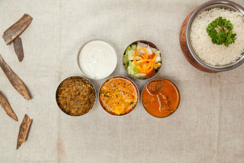Carne bangal indiana thali com arroz integral de caril de galinha korma salada raita servido num prato isolado sobre a vista de ci