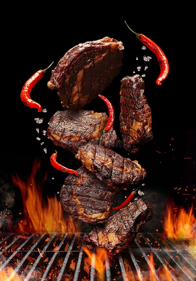 Una foto de carne sobre un fondo negro con un fuego en el medio