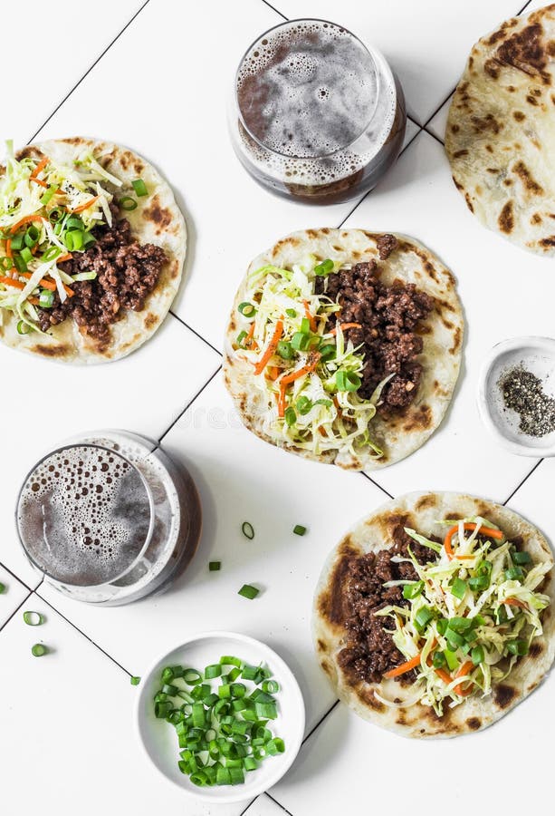 Carne de vaca picante, tacos de la ensalada de col y cerveza oscura en el fondo ligero, visión superior foto de archivo libre de regalías Carne de vaca picante, tacos de la ensalada de col y cerveza oscura en el fondo ligero, visión superior foto de archivo libre de regalías