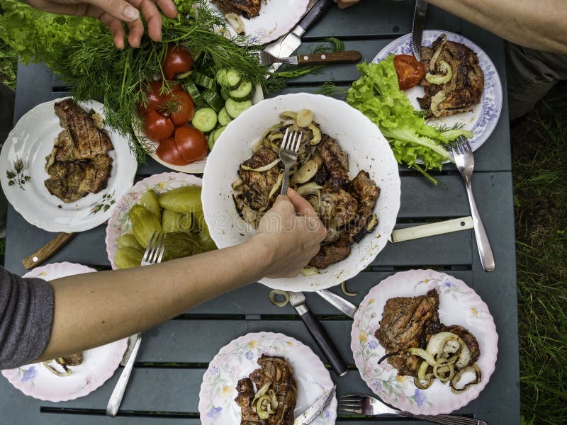 Carne do BBQ na tabela do país Tempo do piquenique da família, opinião superior exterior de partido de jantar, configuração lisa imagens de stock Carne do BBQ na tabela do país Tempo do piquenique da família, opinião superior exterior de partido de jantar, configuração lisa imagens de stock