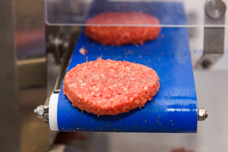 Carne do Hamburger na correia transportadora imagem de stock royalty free Carne do Hamburger na correia transportadora imagem de stock royalty free