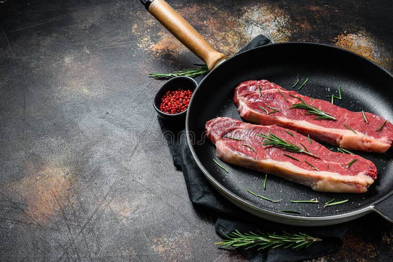 Carne fresca, carne marmoreada, bife de lombo em bruto Fundo escuro Espaço para texto Largura plana fotos de stock royalty free Carne fresca, carne marmoreada, bife de lombo em bruto Fundo escuro Espaço para texto Largura plana fotos de stock royalty free