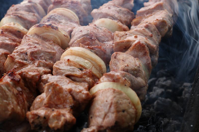 Carne grigliata sulla griglia sulla natura, sui carboni caldi, fumo fotografie stock Carne grigliata sulla griglia sulla natura, sui carboni caldi, fumo fotografie stock