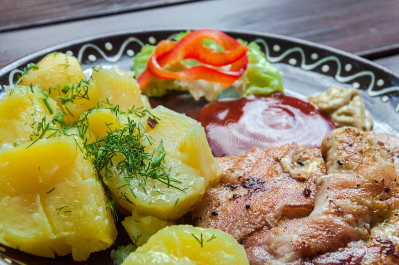 Carne, potatos, y ensalada de la verdura en restaurante en el escritorio de la madera fotografía de archivo Carne, potatos, y ensalada de la verdura en restaurante en el escritorio de la madera fotografía de archivo