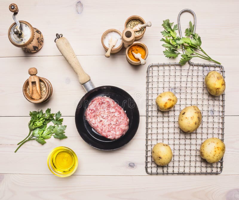 Carne tritata fresca in una padella con una patata sulla griglia per la torrefazione, condente per le erbe degli hamburger sul BA fotografie stock Carne tritata fresca in una padella con una patata sulla griglia per la torrefazione, condente per le erbe degli hamburger sul BA fotografie stock