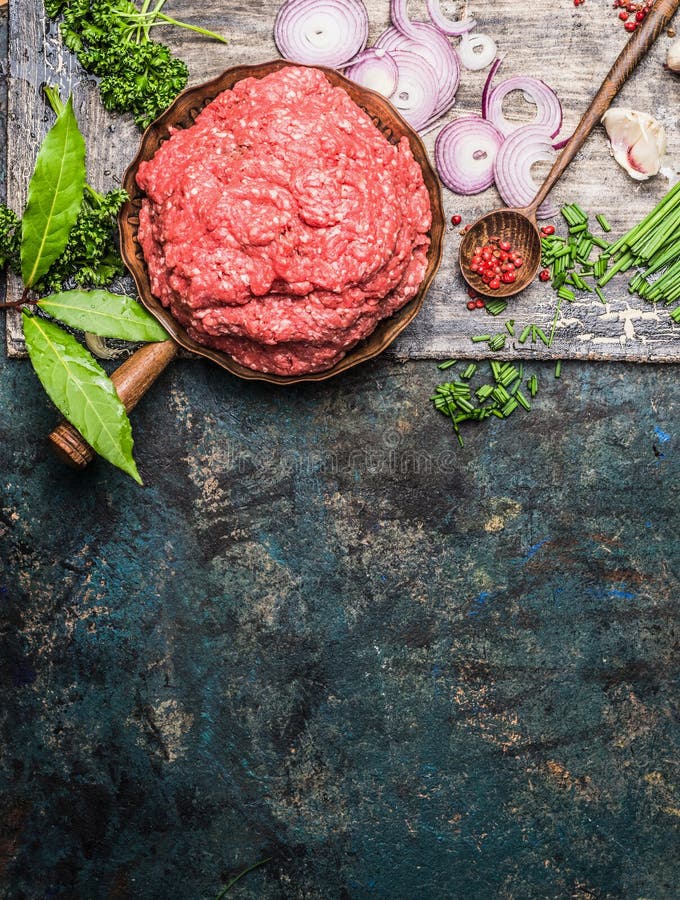 Carne triturada na frigideira com a colher de cozimento de madeira e tempero fresco no fundo rústico, vista superior foto de stock Carne triturada na frigideira com a colher de cozimento de madeira e tempero fresco no fundo rústico, vista superior foto de stock