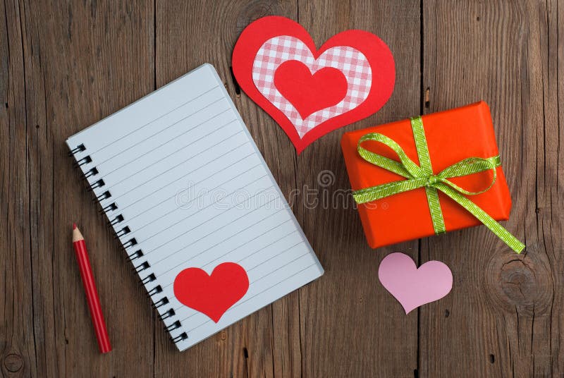 Carnet avec le cadeau, le crayon et les coeurs photographie stock libre de droits Carnet avec le cadeau, le crayon et les coeurs photographie stock libre de droits