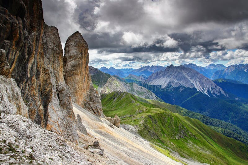 Elevated view of Karnischer Hohenweg path on grassy Alpi Carniche Karnische Alpen main ridge under rock faces of Cavallino Kinigat peak, Italian Austrian border Belluno Veneto Osttirol Europe. Elevated view of Karnischer Hohenweg path on grassy Alpi Carniche Karnische Alpen main ridge under rock faces of Cavallino Kinigat peak, Italian Austrian border Belluno Veneto Osttirol Europe