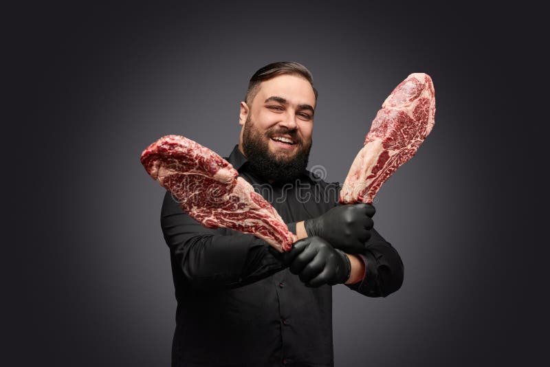 Carnicero amistoso con los pedazos de carne cruda fotos de archivo libres de regalías Carnicero amistoso con los pedazos de carne cruda fotos de archivo libres de regalías