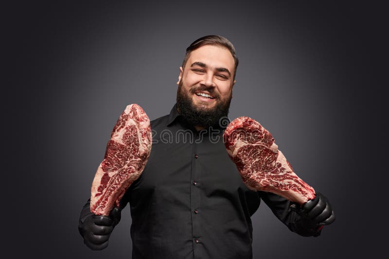 Carnicero barbudo con la carne cruda imágenes de archivo libres de regalías Carnicero barbudo con la carne cruda imágenes de archivo libres de regalías