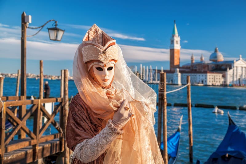 Carnival mask against gondolas in Venice, Italy