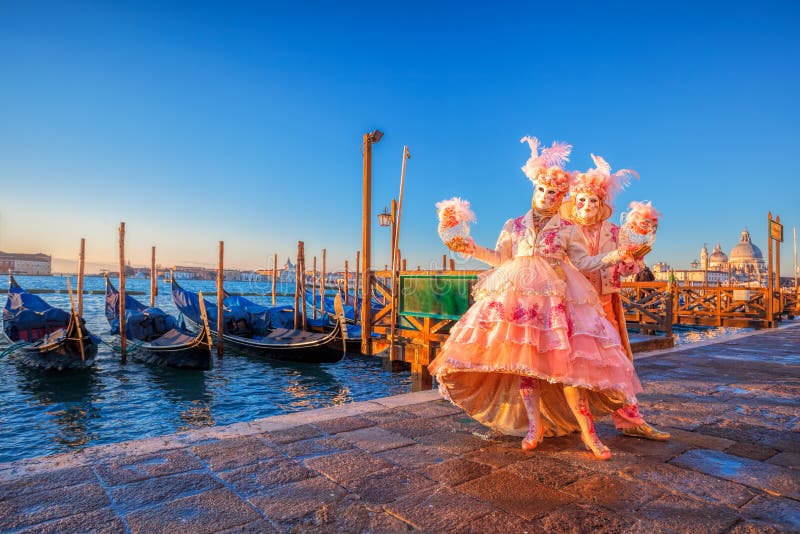 Carnival masks against gondolas in Venice, Italy