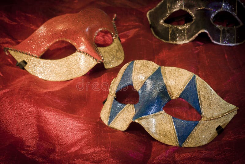 Three carnival masks on red background