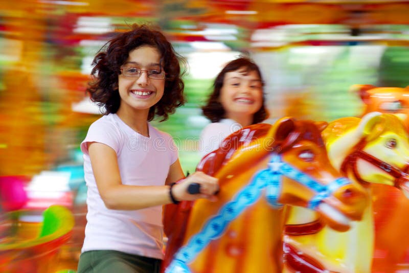 Due ragazze si divertono in un colorato carosello.