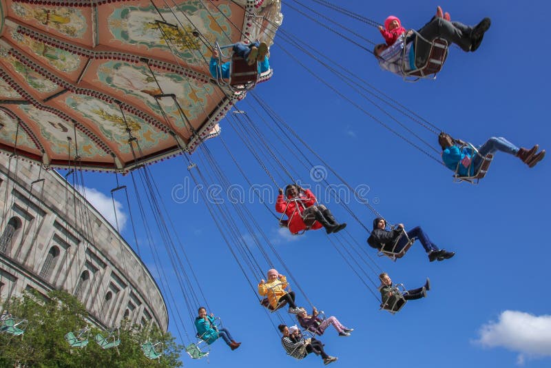 Amusement park, funfair, volksfest in Nuremberg, Germany. Happy,smiling people, children flying in blue sky. Amusement park, funfair, volksfest in Nuremberg, Germany. Happy,smiling people, children flying in blue sky