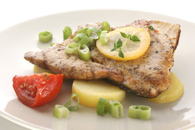Carp fillet with potato, tomato and lemon stock photo