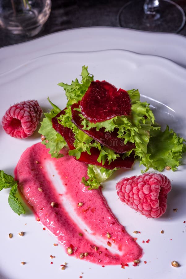 Carpaccio of baked red pray with green salad and raspberry