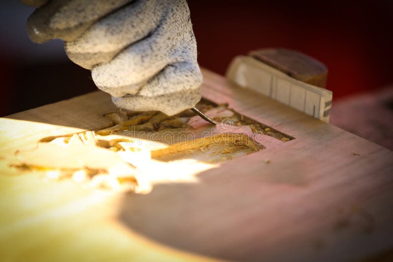 Carpenter carving wood with a chisel