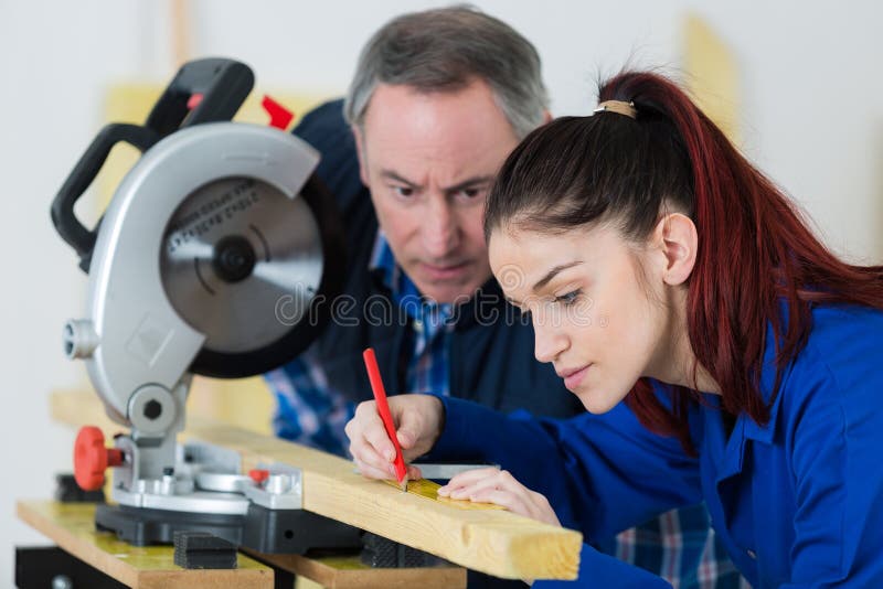 Carpenter with Female Apprentice Working on Building Site Stock Photo