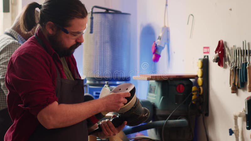 Carpenter changing cut off discs on power tool used to smooth surfaces