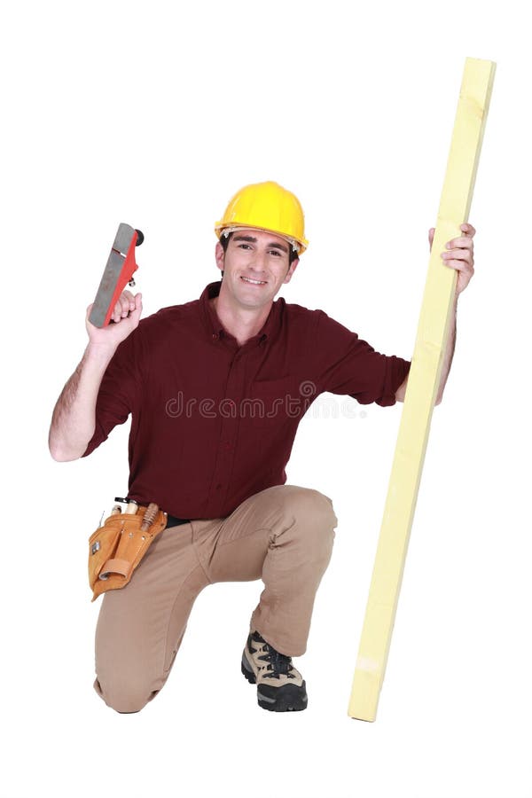 Carpenter kneeling with wood royalty free stock photo