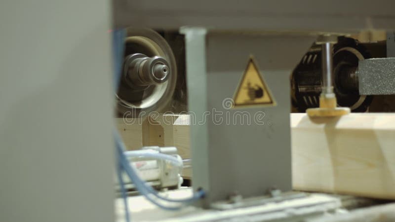 Carpenter machine cuts furrow on wooden block at sawmill facility