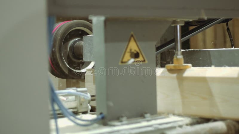 Carpenter machine cuts groove on wooden block at sawmill facility