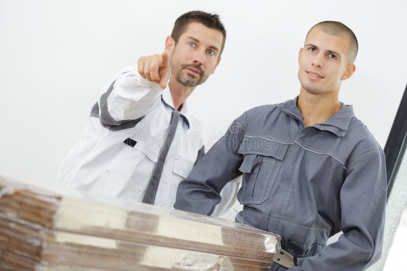 Carpenter pointing towards incomplete building royalty free stock photos