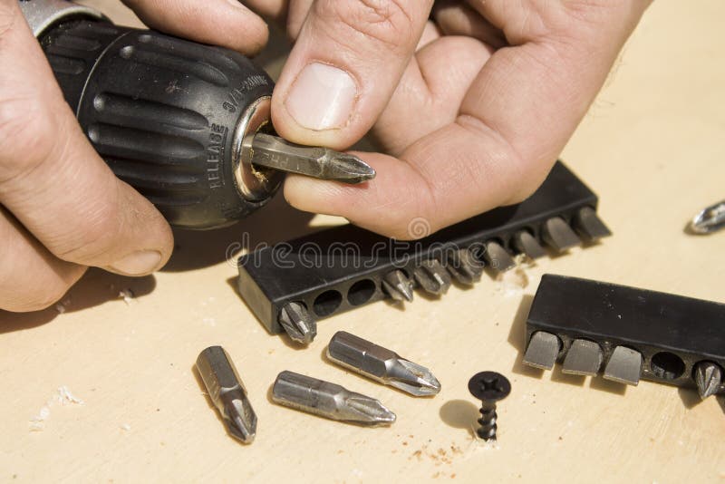 Carpenter`s hands changing the tip of the tip in the screwdriver stock photos Carpenter`s hands changing the tip of the tip in the screwdriver stock photos