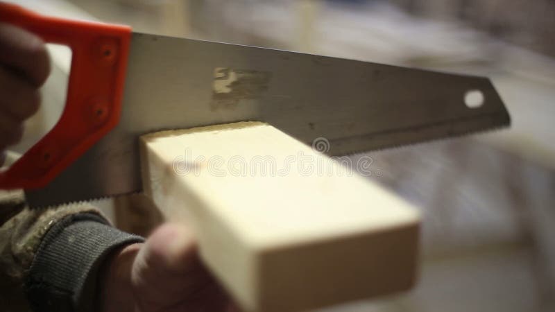 The carpenter saws off the block with a hacksaw