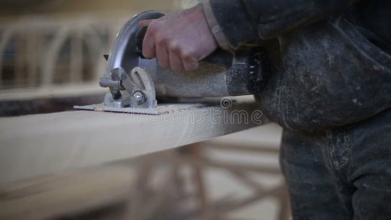 A carpenter saws off a board with a disk saw