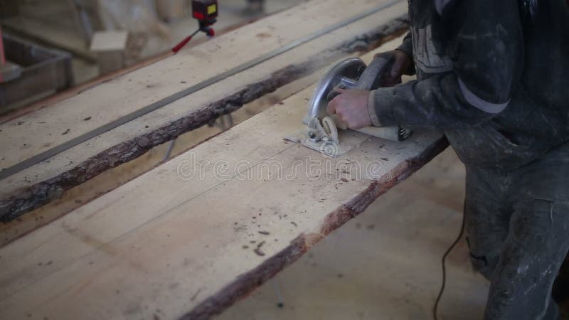 A carpenter saws off a board with a disk saw