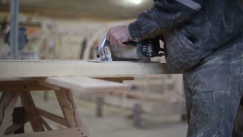 A carpenter saws off a board with a disk saw