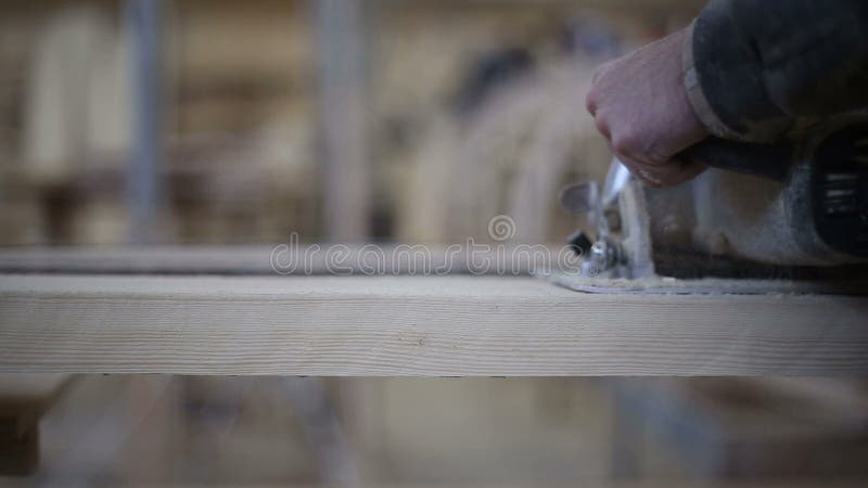 A carpenter saws off a board with a disk saw