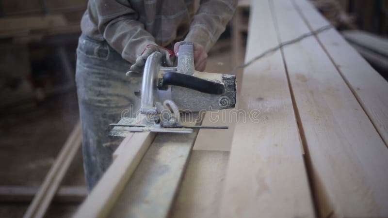 A carpenter saws off a board with a disk saw